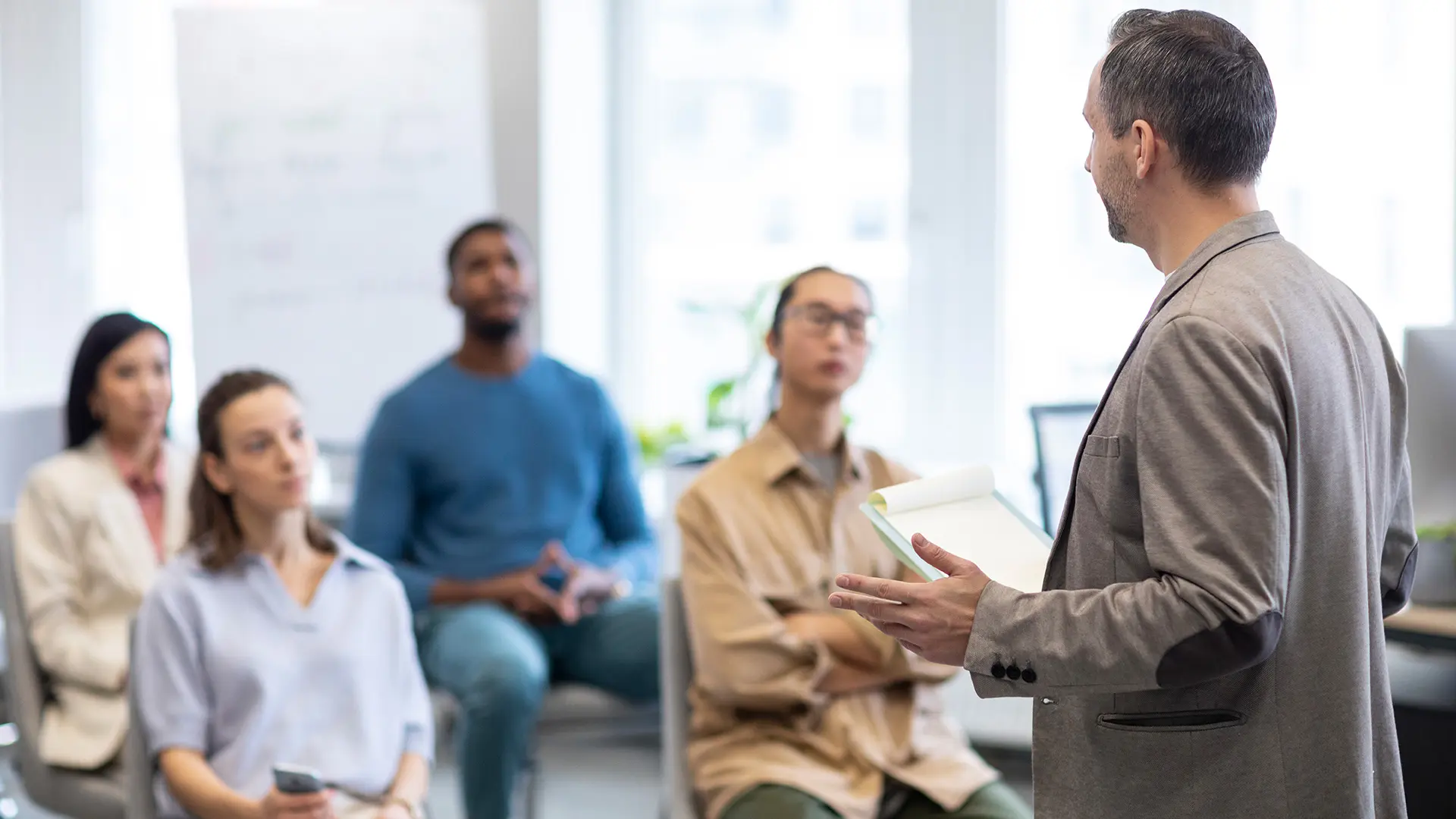 A person giving a presentation to a small group in a modern office.