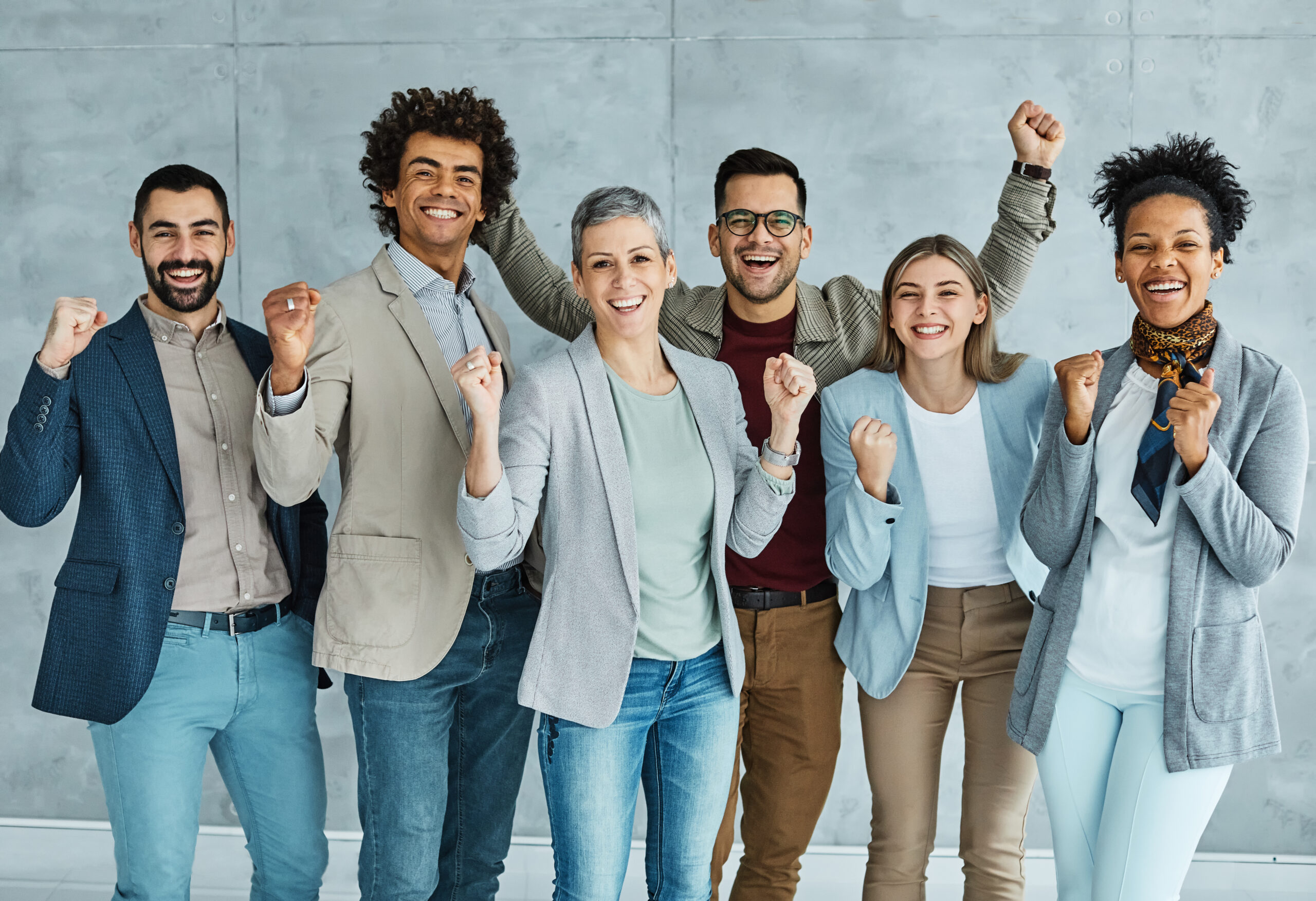 Diverse group of happy professionals celebrating success together.
